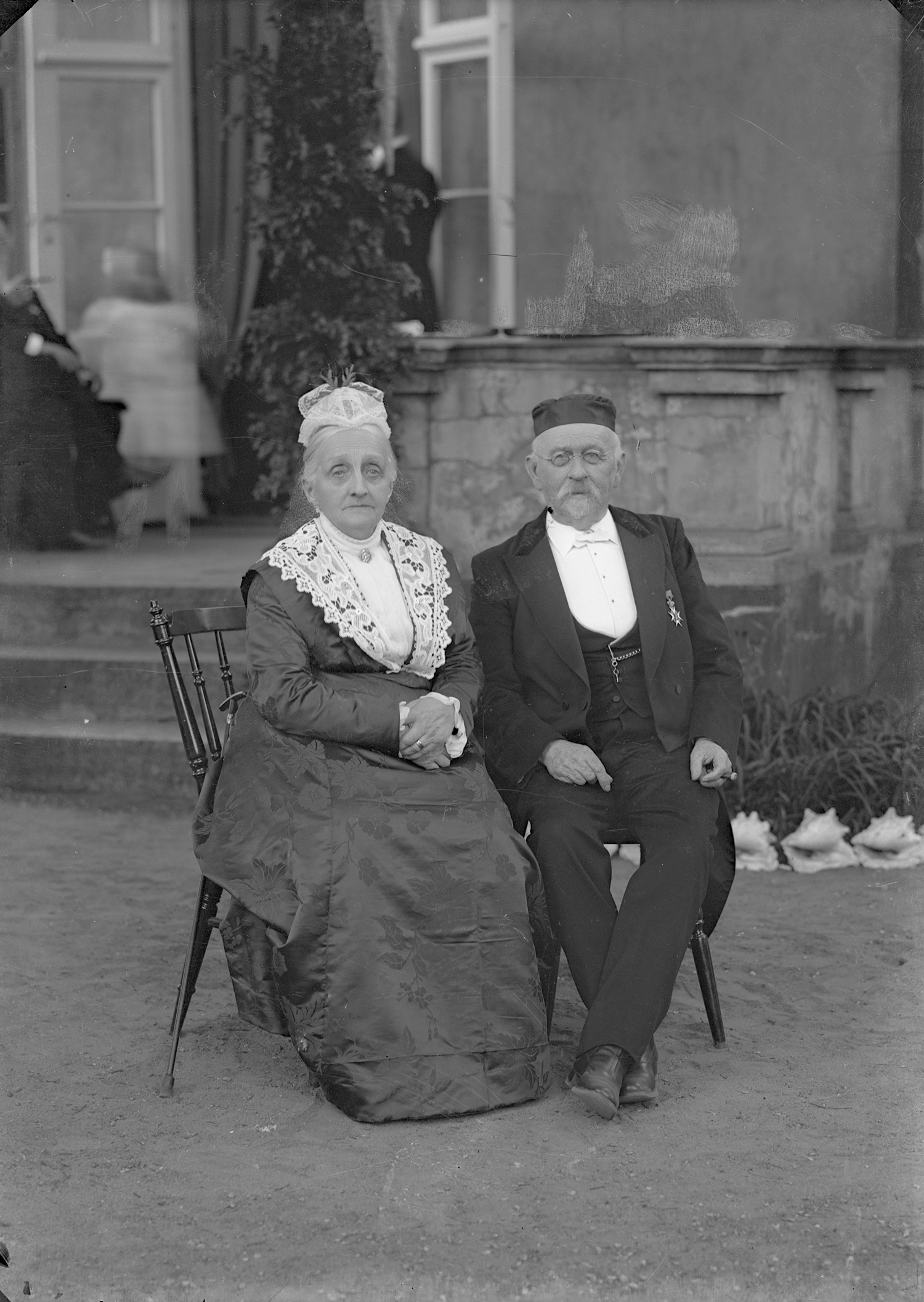 Doktor Walter Str&ouml;m och hans hustru Karin. Herr och fru Str&ouml;m, sittandes utomhus. Esl&ouml;vs f&ouml;rste l&auml;kare, &ouml;ppnade praktik 1865. K&auml;lla: Esl&ouml;vs kommuns bildarkiv, F&ouml;jers foto.