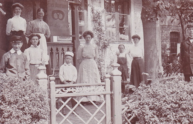 Bageriiderskan Emma Andersson, intill "Kringlan", med sin famillj. T.h. skymtar byggm. Svenssons verkstad, riven i 1910-talets f&ouml;rsta &aring;r.