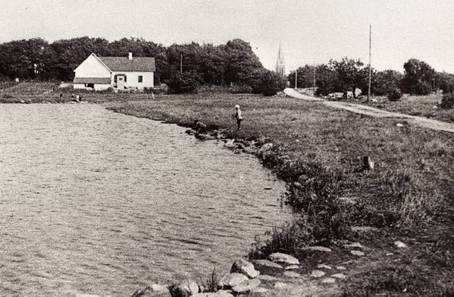  Trollsjön i Eslöv i början på 1900 talet med så kallade Småbrukarhemmet (rivet) och kyrkan i bakgrunden. Foto: KG Pressfoto.