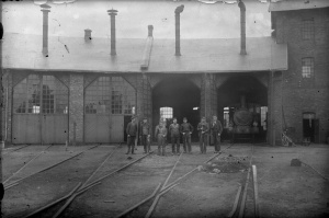 Lokstallet i Billinge omkring 1915. Stallpersonalen med HHJ lok 3 "Ramlösa" inne i stallet. Stallet eldhärjades 1932 och återuppbyggdes aldrig. Foto: Järnvägsmuseet.