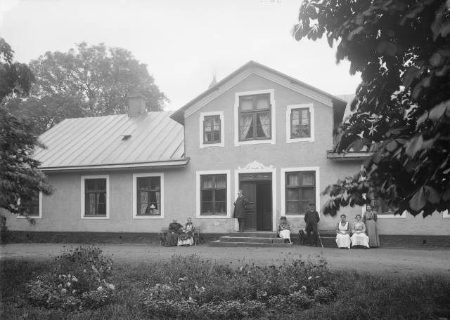 Kyrkoherde Edelberg med familj samlad framför Västra Sallerups prästgård. Källa: Eslövs kommuns bildarkiv/Föjers foto.