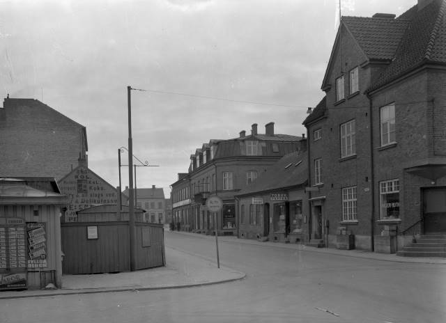 Västergatan in mot torget. I huset till höger på hörnet, fanns V. Sallerups Mejeri, i slutet 1930-talet, början 1940-talet. Lilla huset till vänster om Mejeriet, fanns Olssons Pappersaffär, och Månssons Matsalar. Till vänster revs byggnaderna, för att lämna plats till Johan Nilssons byggnader. Föjers arkiv.